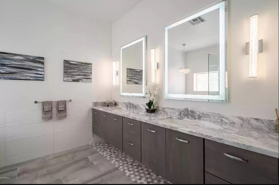 Wall-hung grey oak double vanity with a natural stone counter and two backlit mirrors