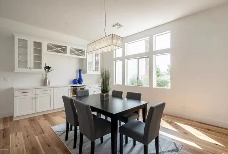 Dining room with a white built-in cabinet run, glass-front upper doors and an integrated beverage cooler